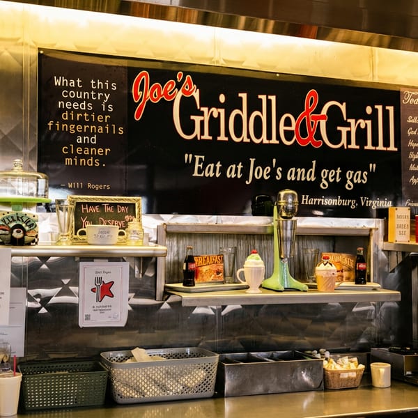 Retro diner counter with "Joe's Griddle & Grill" sign and Route 66 decor.